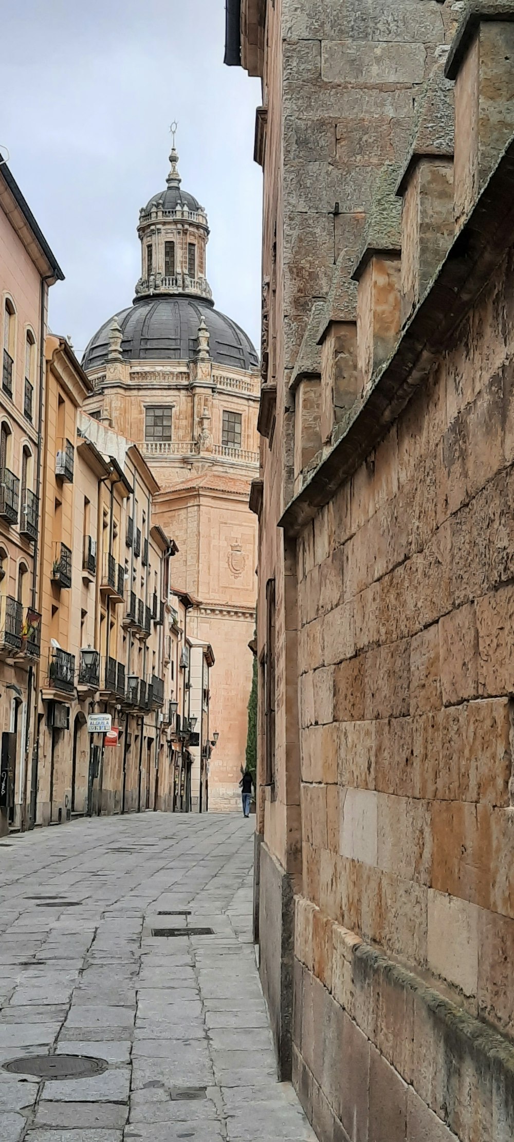 a stone street with a clock tower in the background