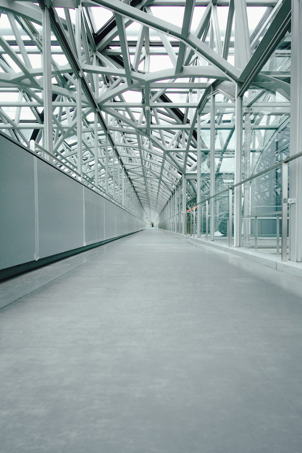 an empty walkway in a large building with lots of windows