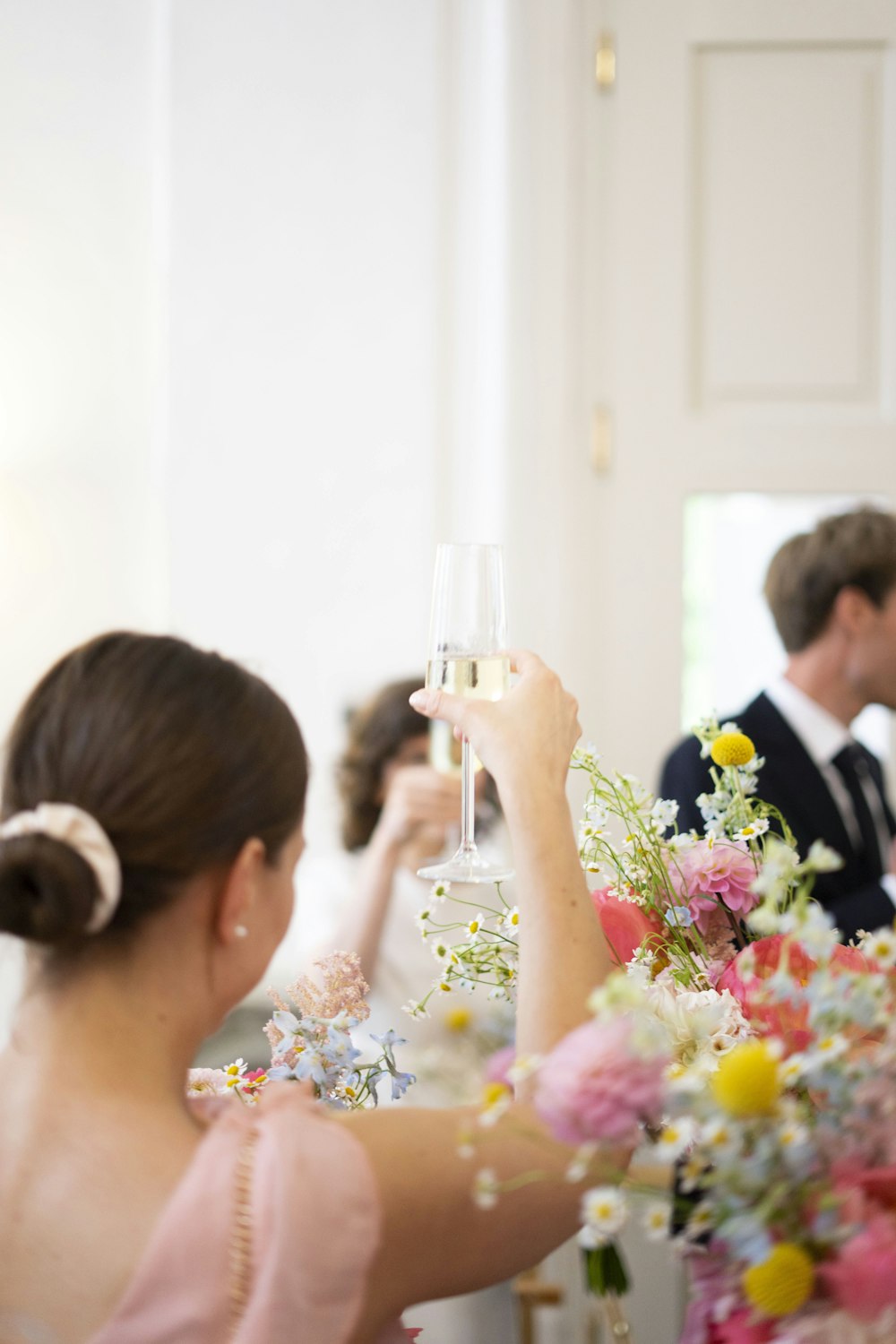 a woman in a pink dress holding a glass of wine