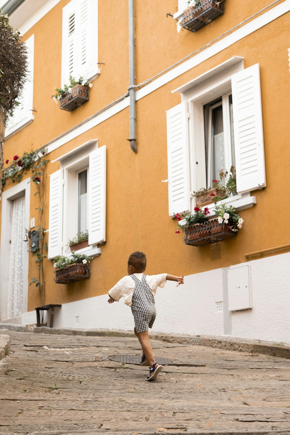 a little boy that is standing in front of a building