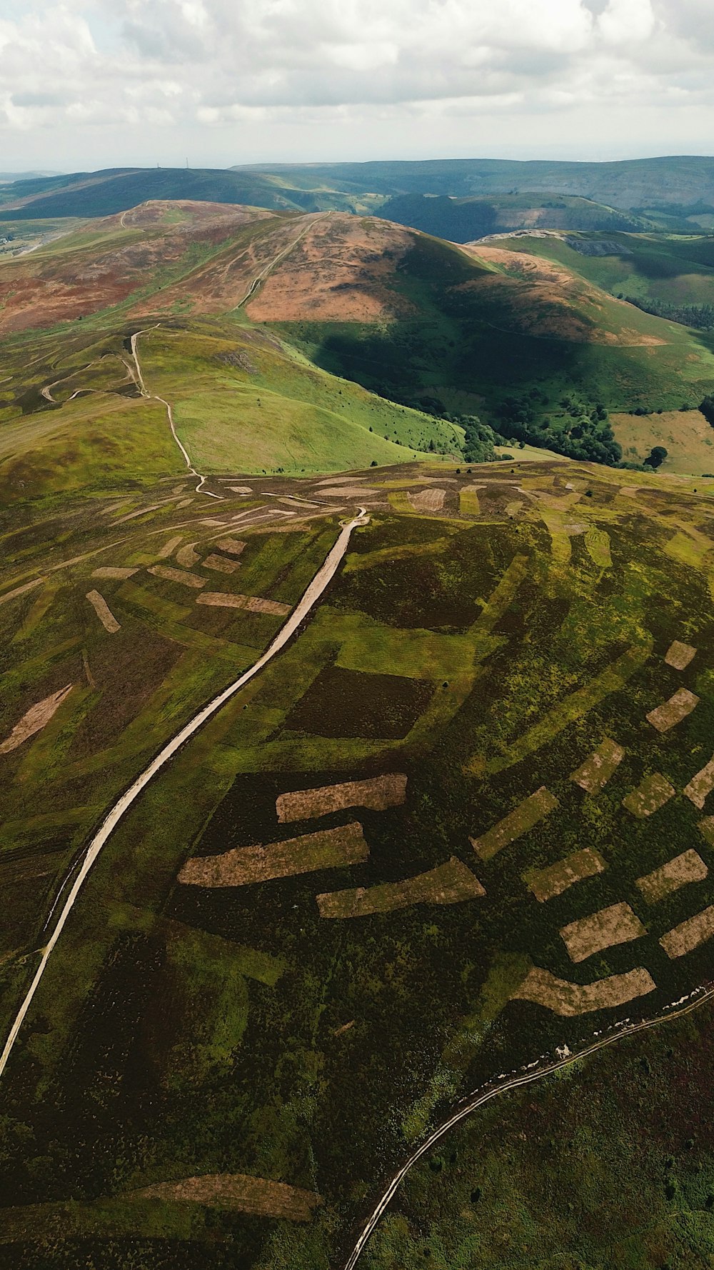 an aerial view of a grassy area with a road running through it