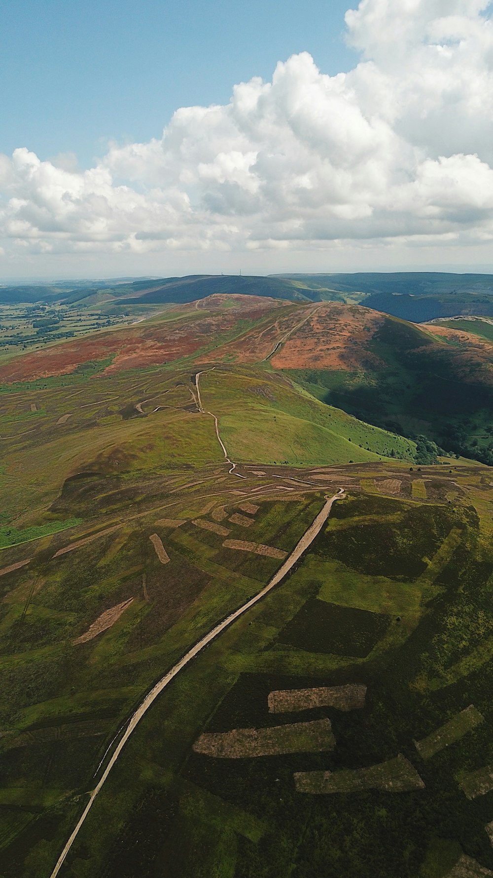 an aerial view of a grassy field with a road running through it