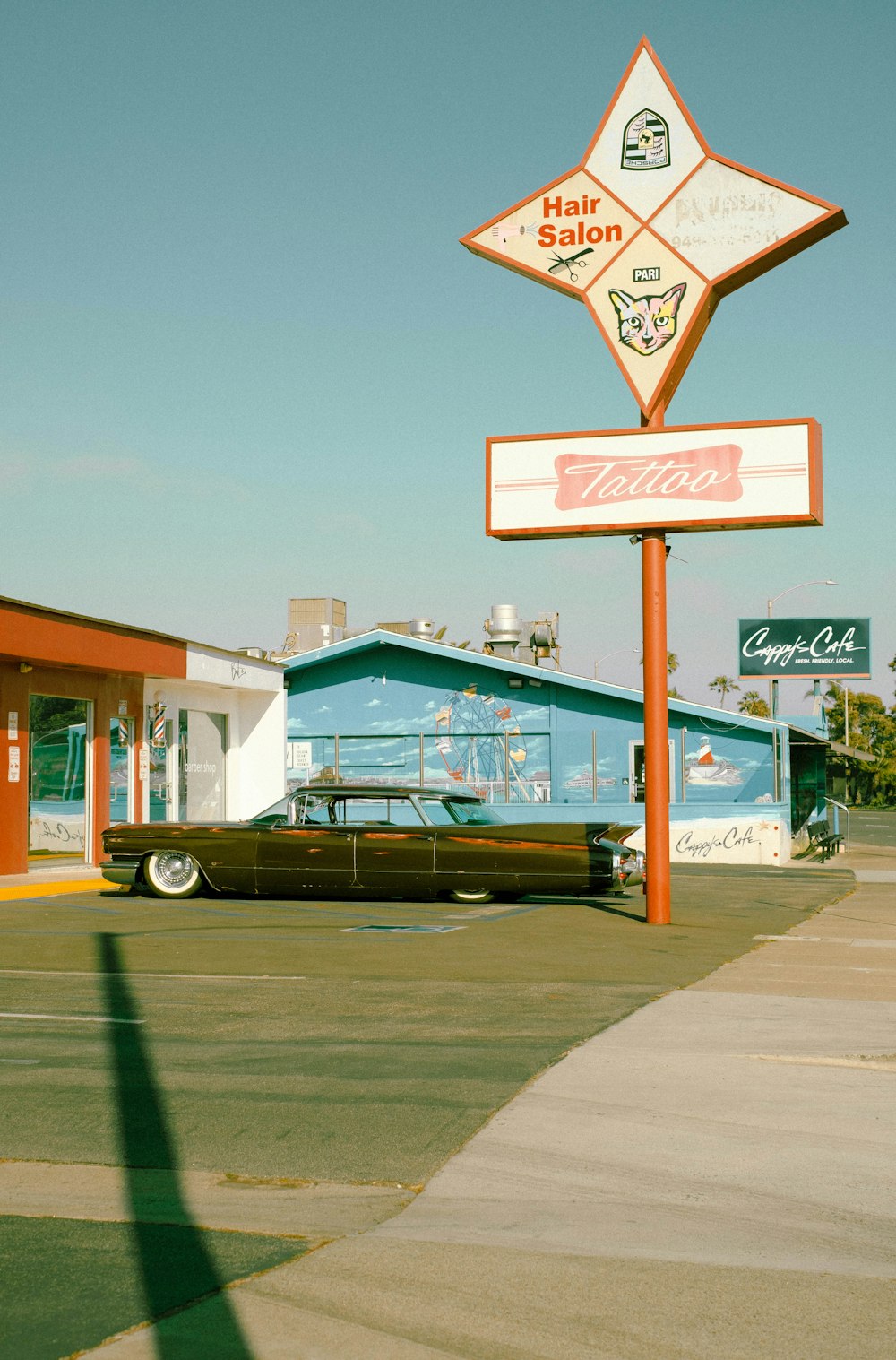 an old car parked in front of a hair salon