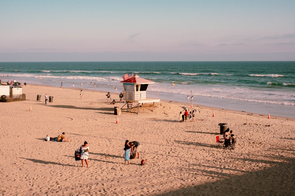 a group of people standing on top of a sandy beach