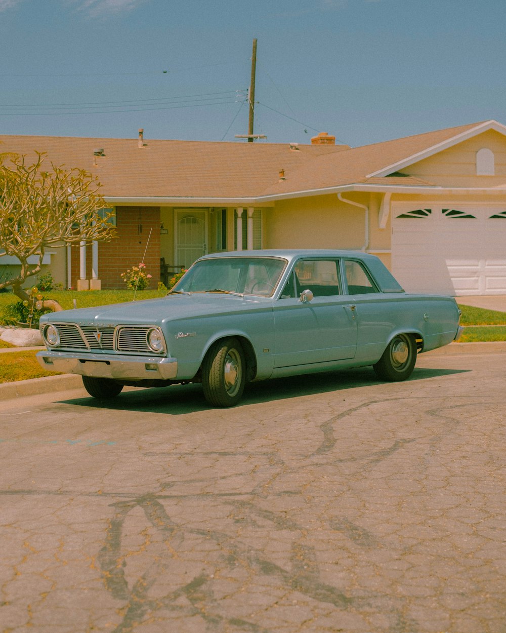 Une voiture bleue garée devant une maison