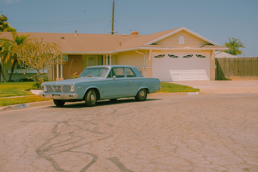 a blue car parked in front of a house