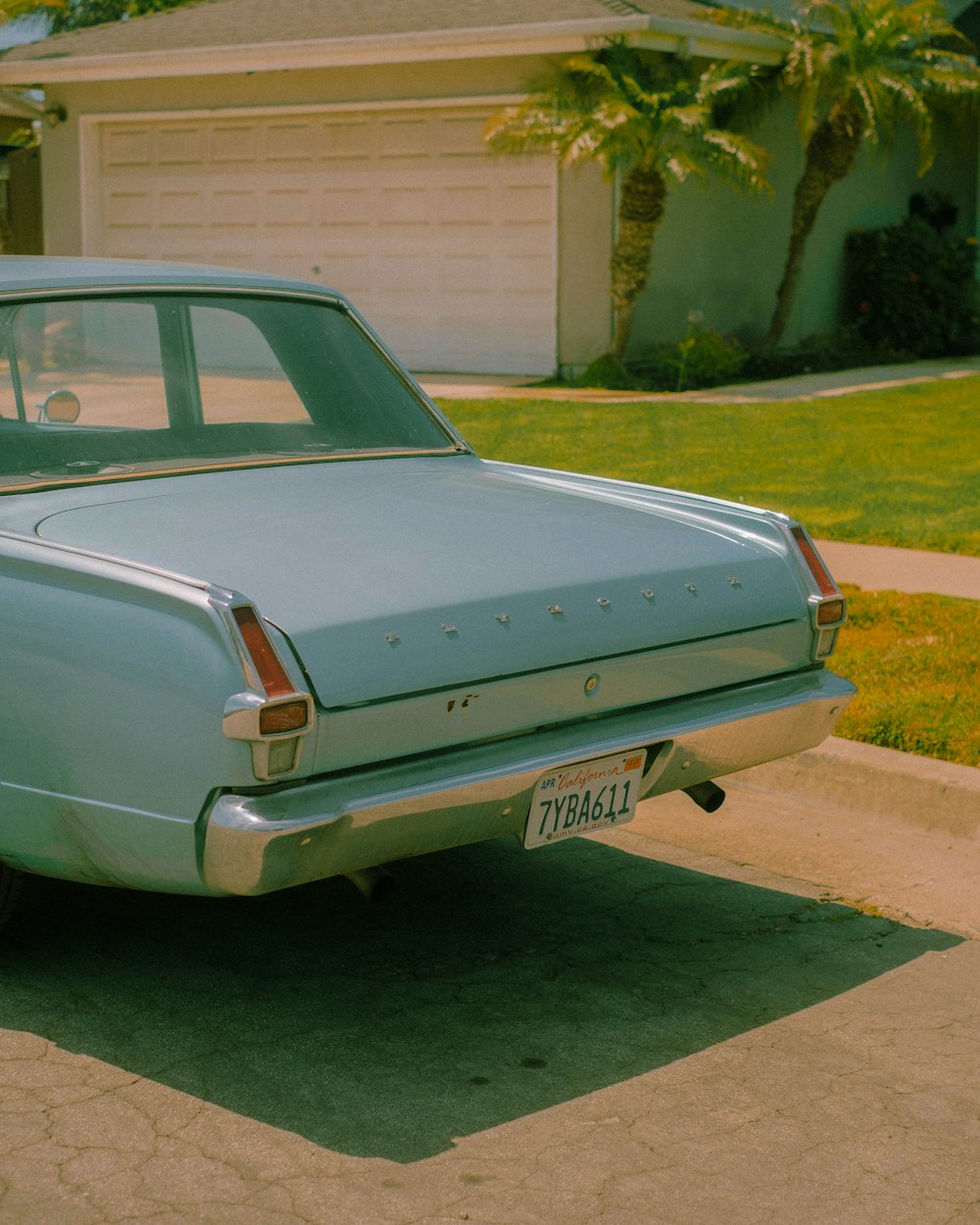 a blue car parked in front of a house