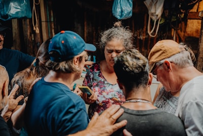A warm gathering of community members praying together in a cozy church hall.