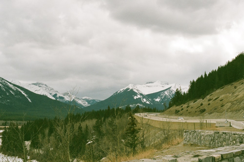 a scenic view of a road with mountains in the background