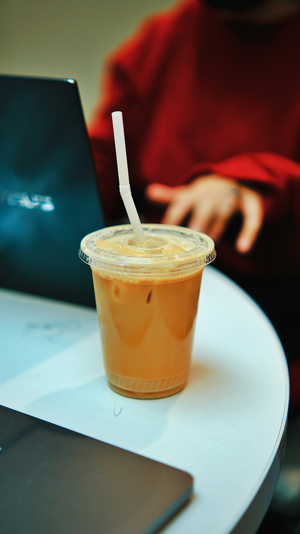 una taza de café sentada en una mesa junto a una computadora portátil