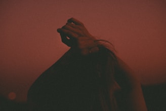 A powerful silhouette of a person lifting their hands to the sky in a moment of transformation.