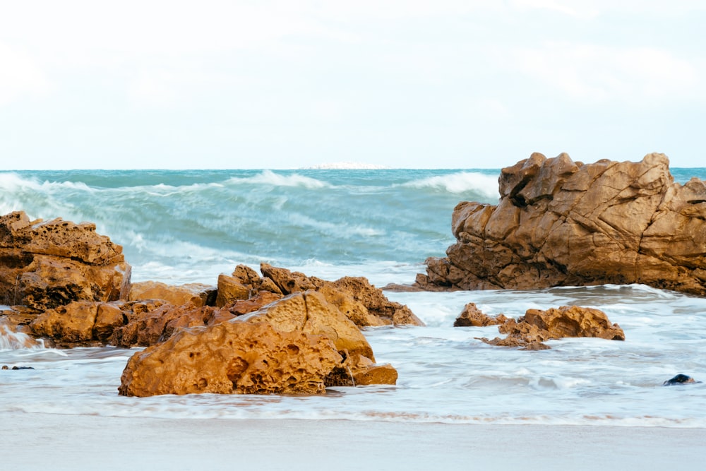 a couple of large rocks sitting on top of a beach