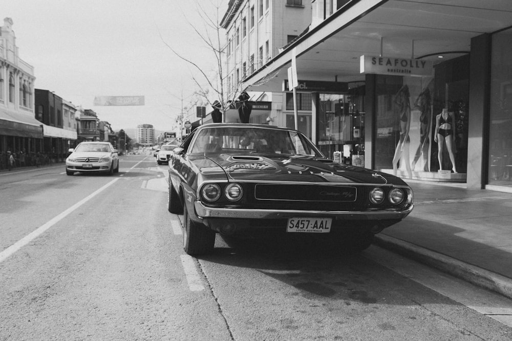 a black and white photo of a car parked on the side of the road