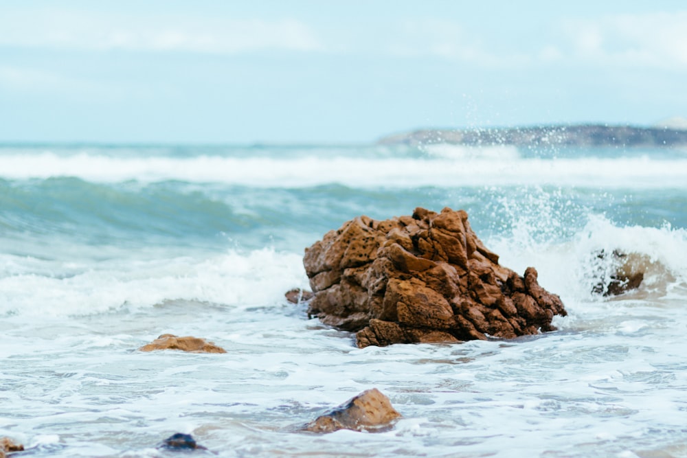 a rock sticking out of the ocean water