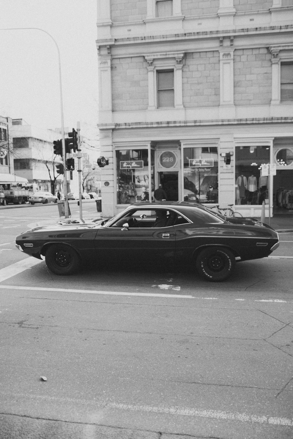 Una foto in bianco e nero di un'auto su una strada