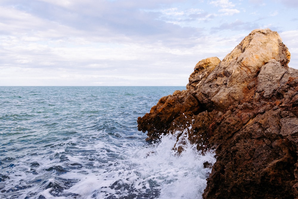 a large rock sticking out of the ocean