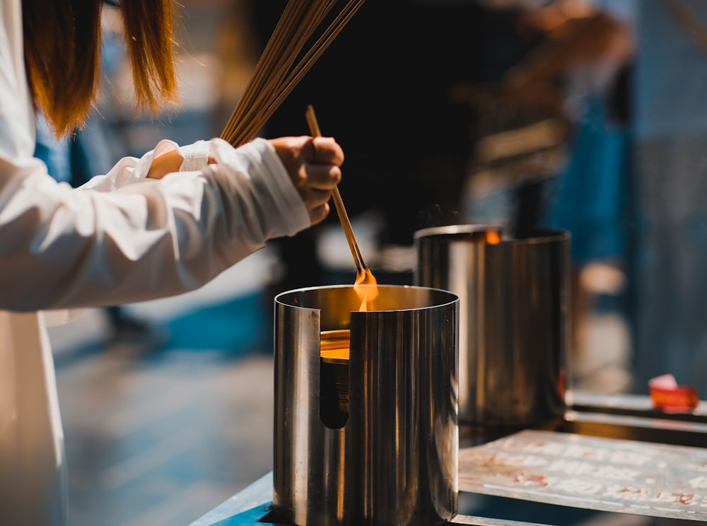 a woman stirring a pot with a wooden spoon