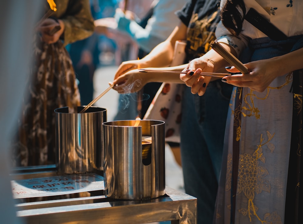 a group of people standing around a table with pots and pans