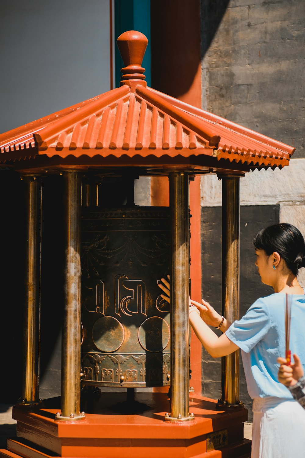 a woman standing next to a bell in a building