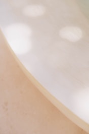 Soft, diffused light creates a serene and calming atmosphere with gentle shadows and abstract patterns on a smooth, pale surface.