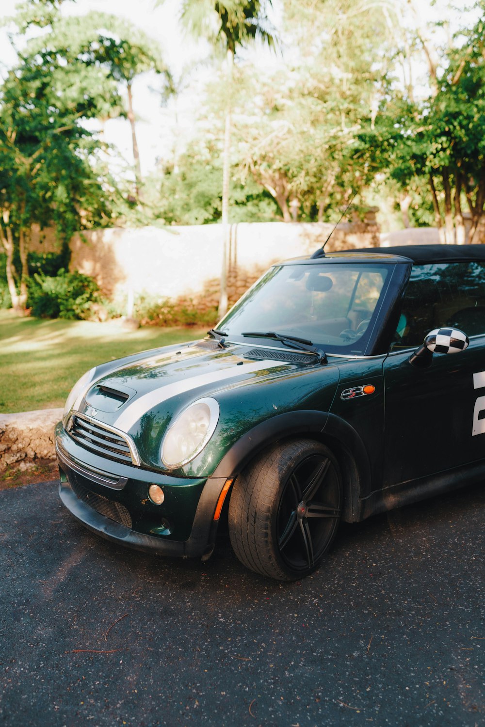 a small green car parked on the side of the road