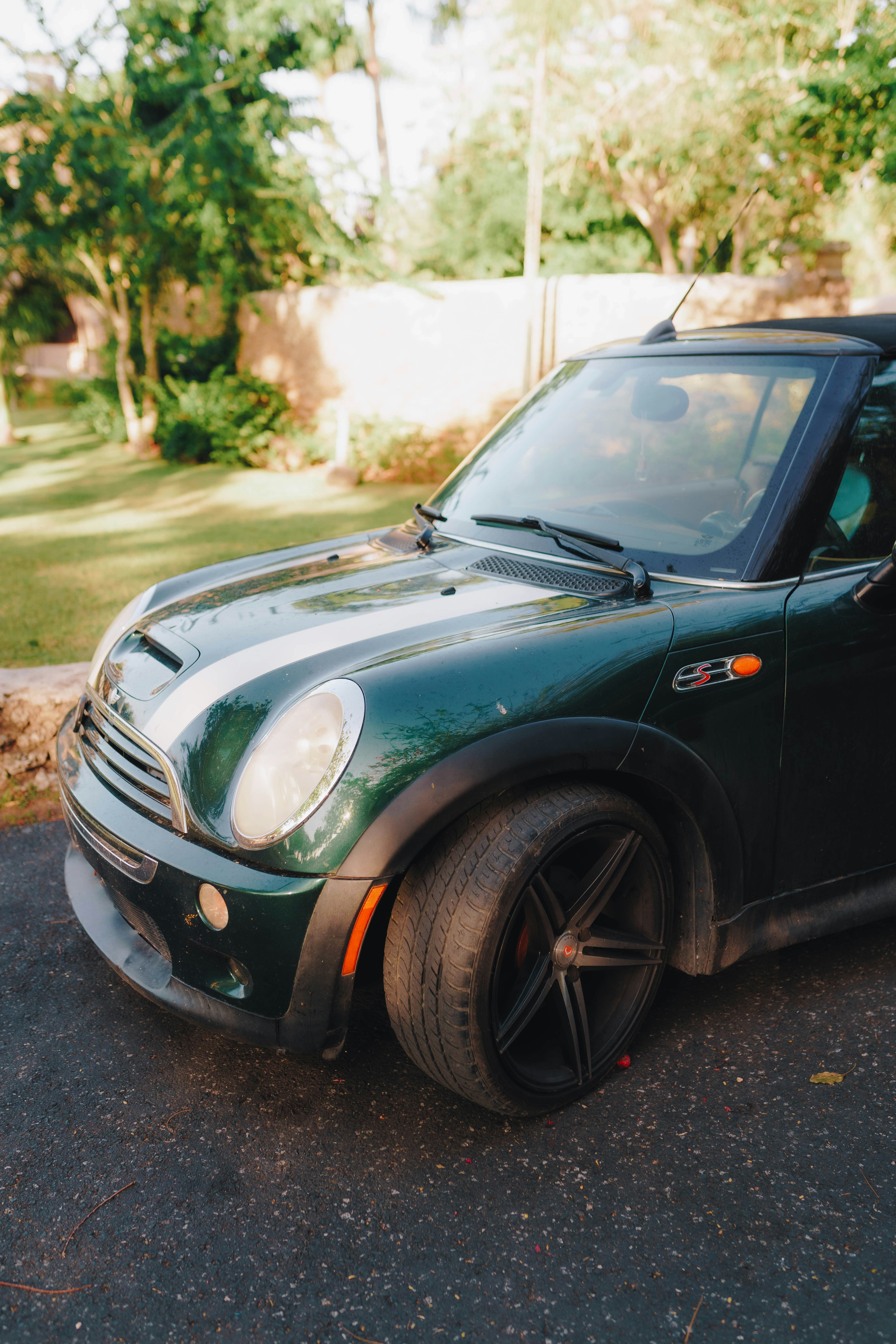 a small green car parked on the side of the road