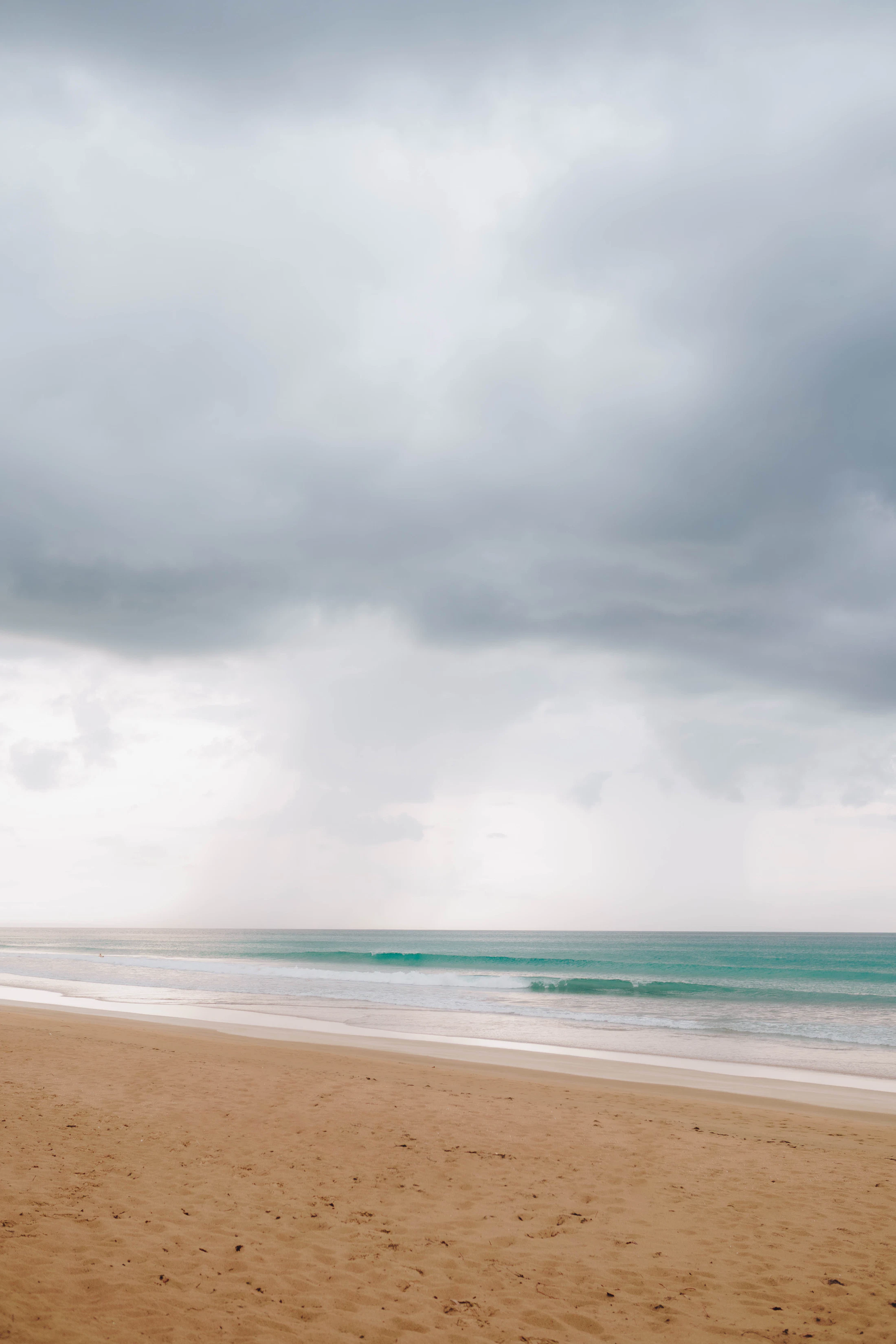 A surfer walking the shoreline at Punta Popy