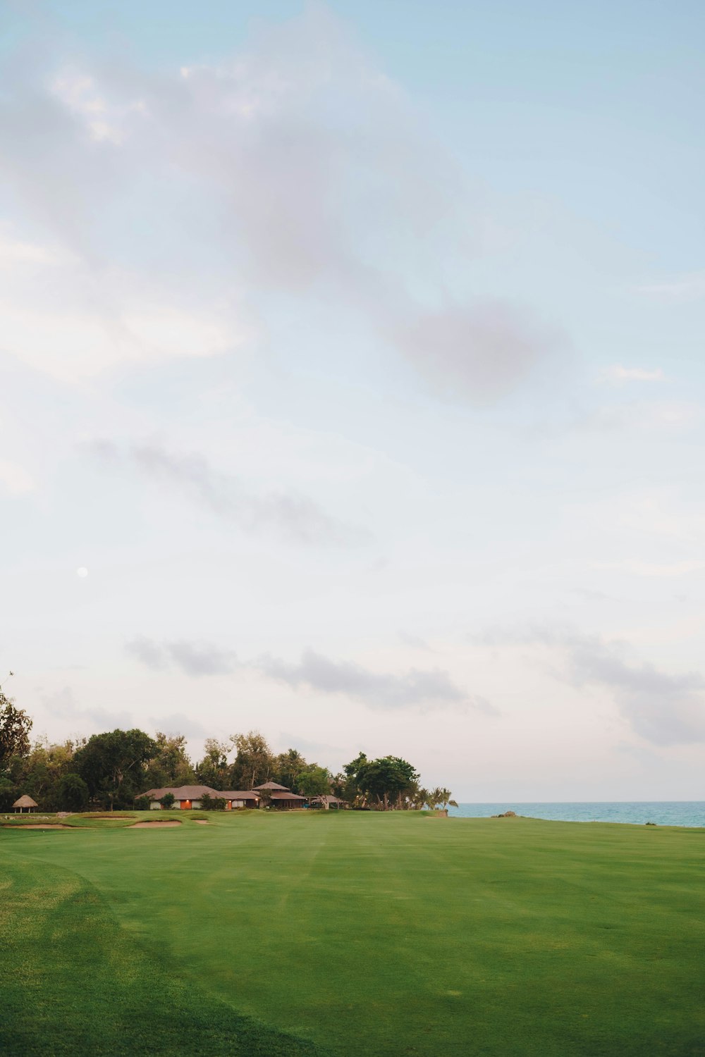a green golf course with a view of the ocean