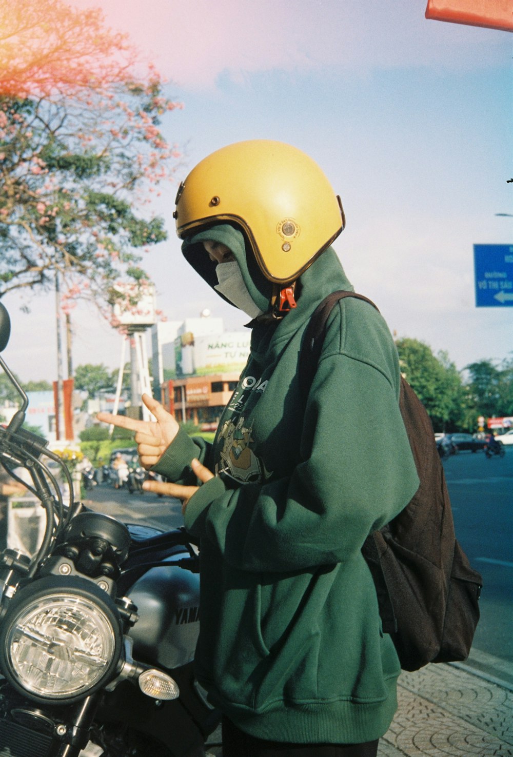 a person wearing a helmet standing next to a motorcycle