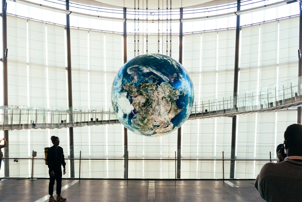 a man standing in front of a giant glass globe