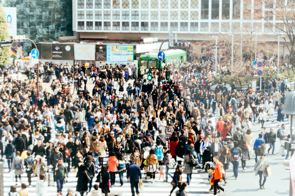 a large crowd of people walking across a street