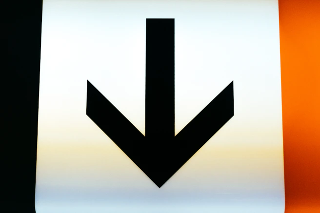 a close up of a sign with an arrow pointing down