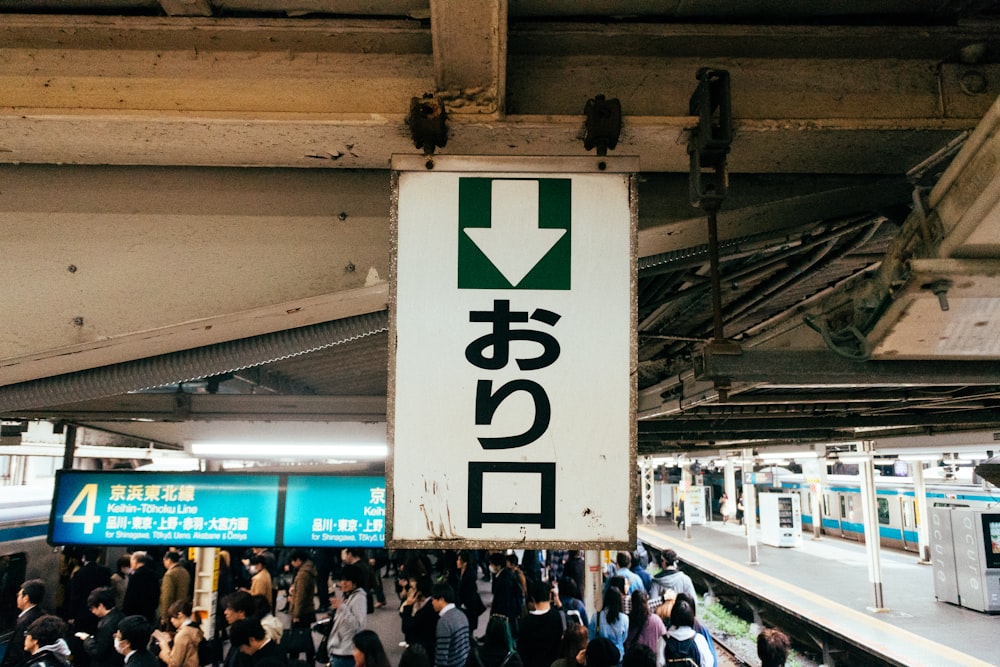 a sign hanging from the ceiling of a train station