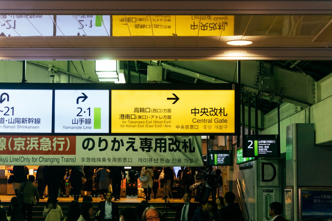 a group of people standing around a train station,