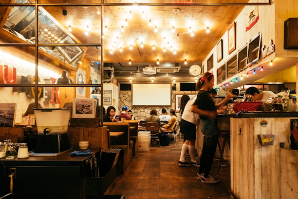 A cozy restaurant interior with warm lighting and wooden decor, inviting guests to relax and enjoy their meals.