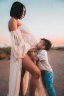 a pregnant woman and a toddler boy pose for a picture