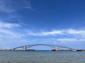 a bridge over a body of water under a blue sky
