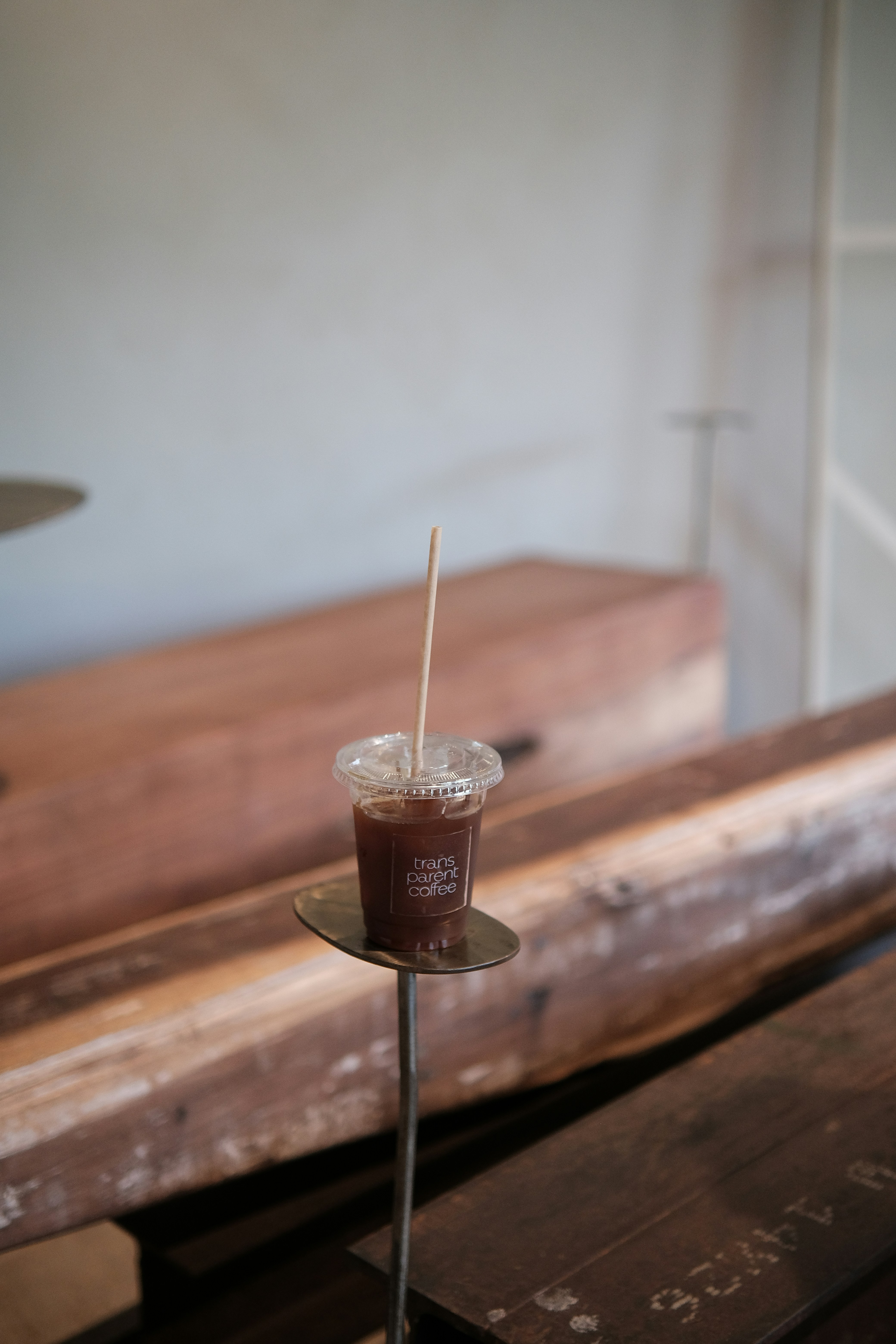 a drink sitting on top of a table next to a wooden bench