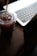 A close-up of a modern laptop on a wooden desk with a coffee cup beside it.