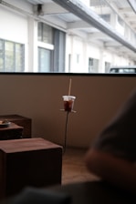 Minimalist modern cafe interior with a wooden table displaying a cup of black coffee and a croissant.