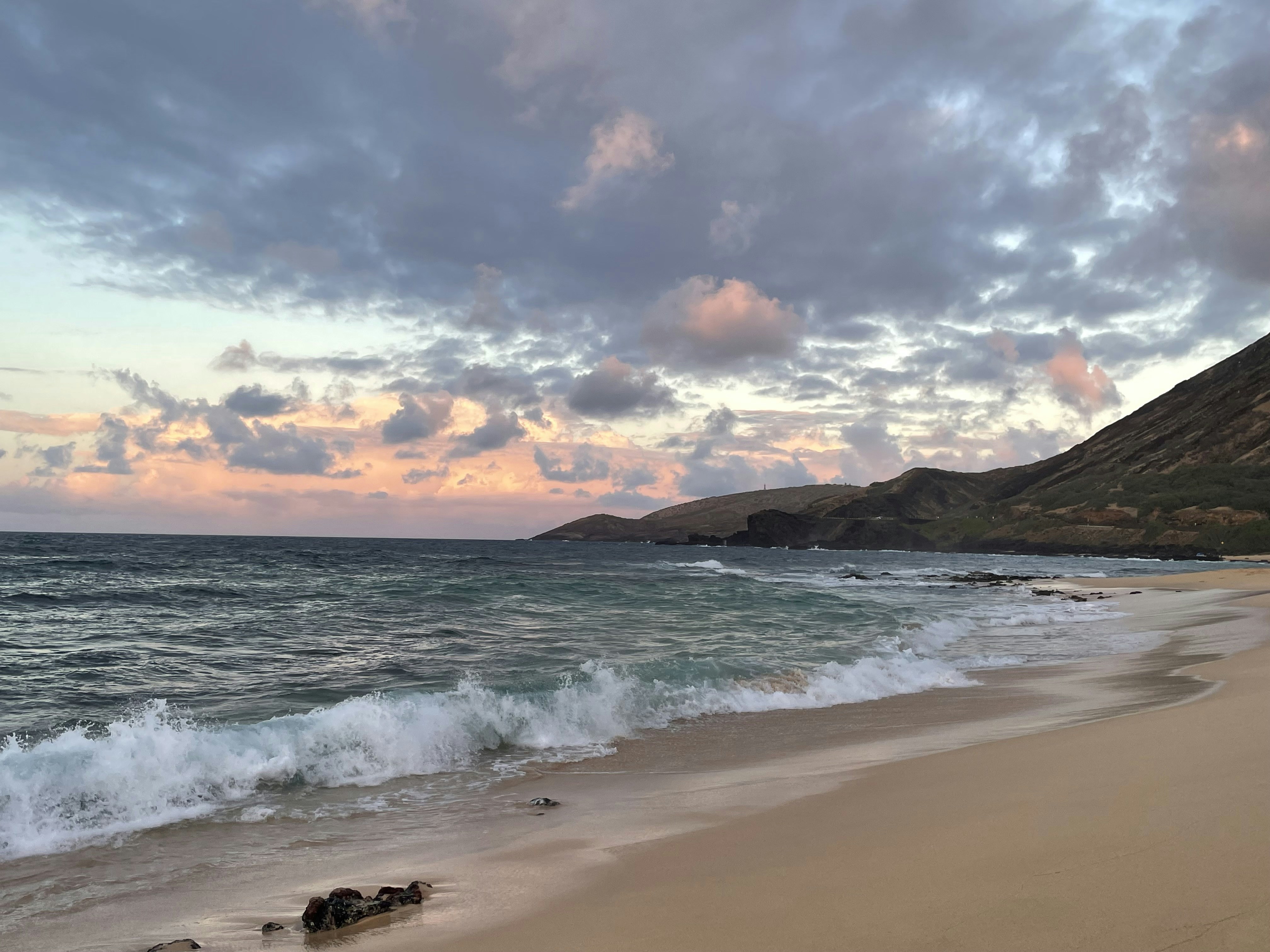 a sandy beach with waves coming in to shore