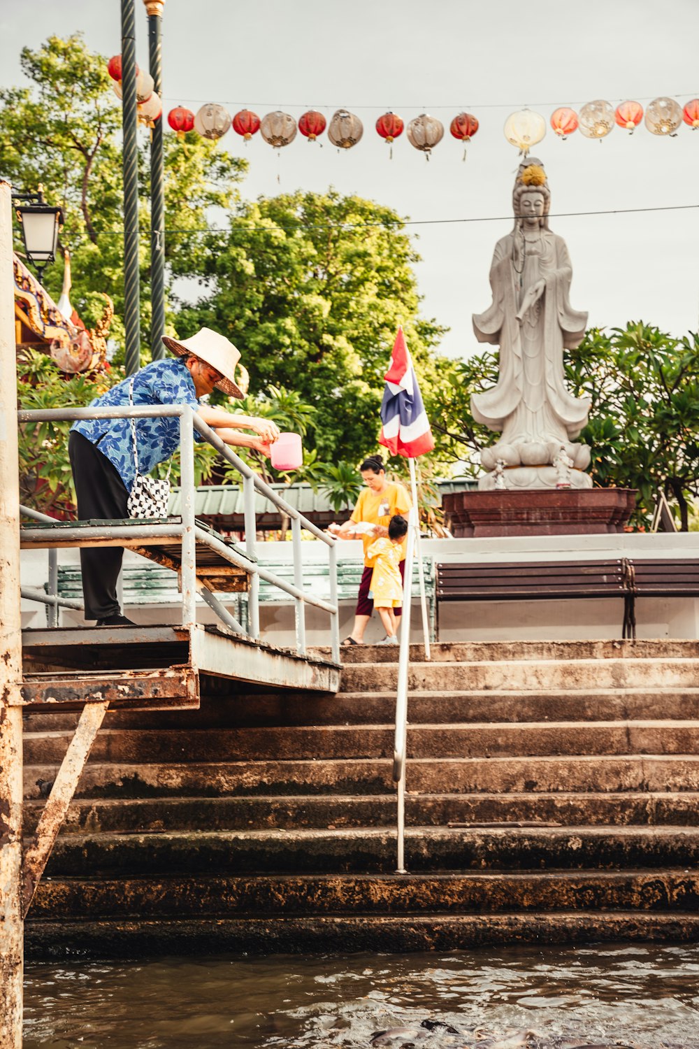 a man standing on a set of stairs next to a statue