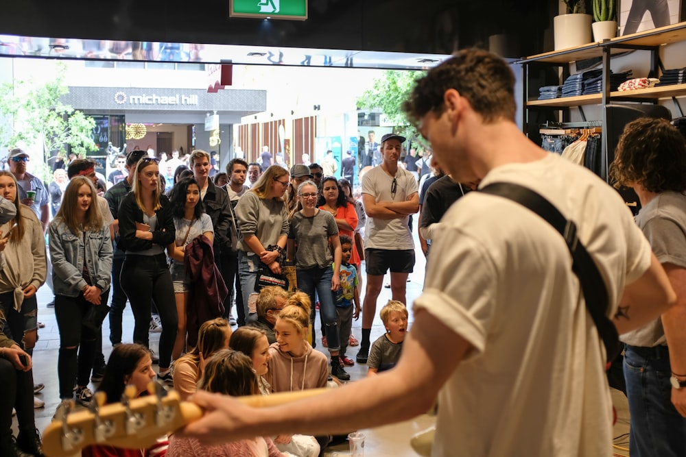 a man playing a guitar in front of a crowd of people