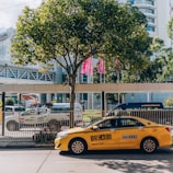 a yellow taxi cab parked in front of a tall building