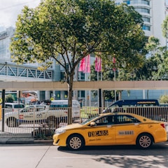 a yellow taxi cab parked in front of a tall building