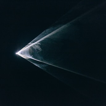 a black and white photo of a light in the dark