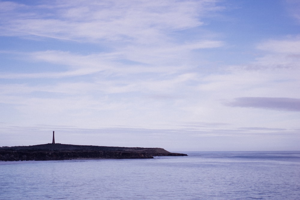 a lighthouse on a small island in the middle of the ocean