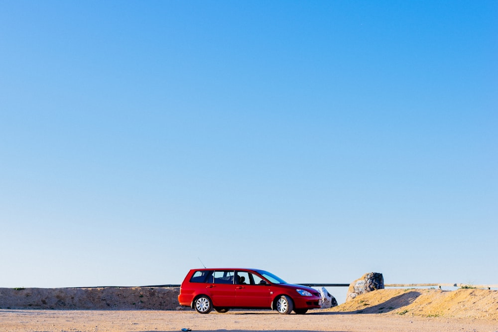 a red car is parked on the side of the road