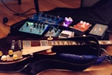 Close-up of a guitar with vintage effects pedals during a recording session.