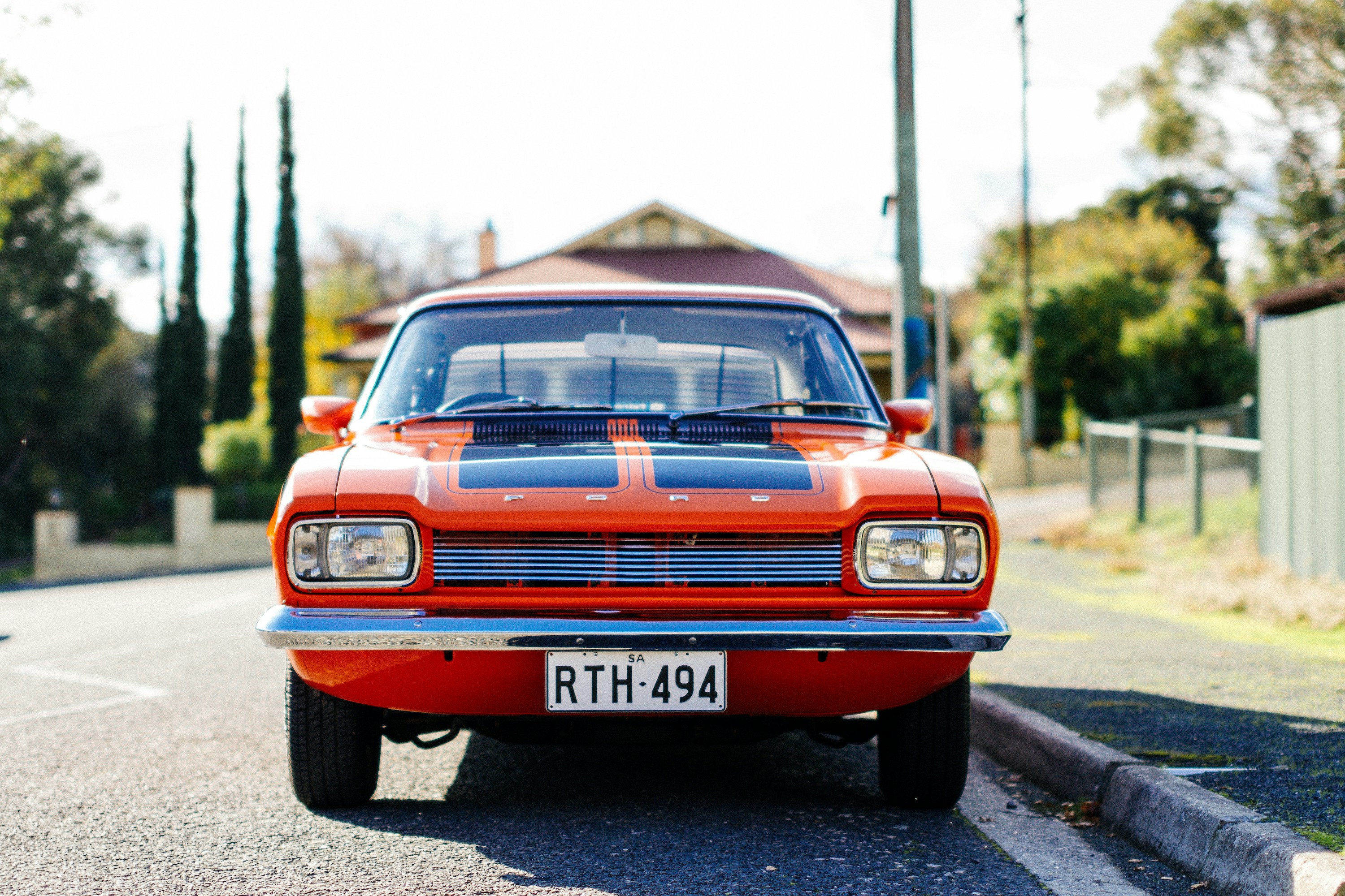 an orange and black car parked on the side of the road